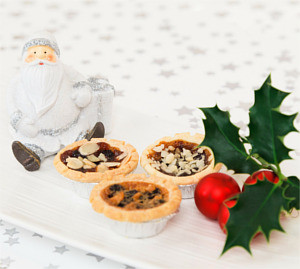 photo of mince pies next to small santa figure dressed in white